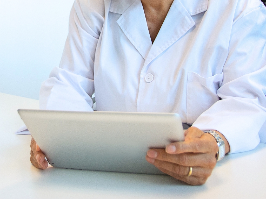 Doctora sostiene tablet en la consulta